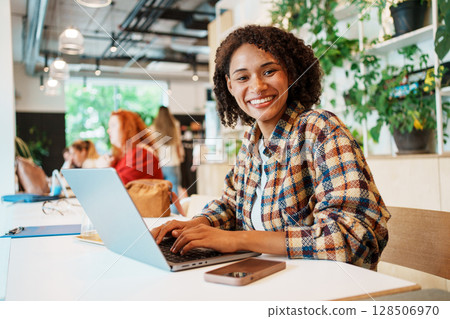 Young Professional Working in a Modern Caf Environment Young Professional Working in a Modern Caf Environment 128506970