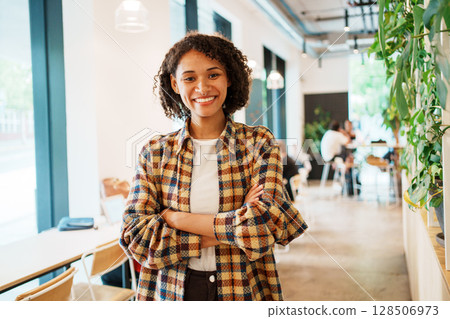 A Confident and Cheerful Young Woman in a Cozy Cafe Environment, Engaging with Friends 128506973