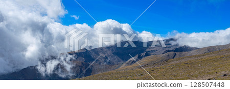 Cloudy over mountains on hiking trail to Mulhacen peak, Sierra Nevada National park, Andalusia, Spain 128507448