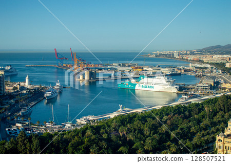 Savoring the stunning panoramic view of the vibrant city and bustling port while soaking in the charm of the coastal atmosphere in Malaga, Spain 128507521