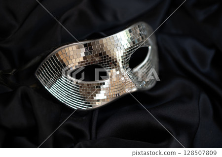 Carnival masquerade mirror man mask, mysterious accessory for a party on black fabric Carnival masquerade mirror man mask, mysterious accessory for a party on black fabric 128507809