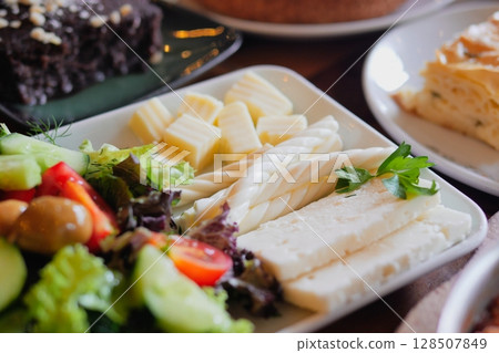 An exquisite and delicious platter featuring fresh salad and gourmet cheese An exquisite and delicious platter featuring fresh salad and gourmet cheese 128507849