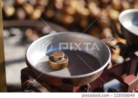 Balance scale displaying a weight in a market setting 128508049