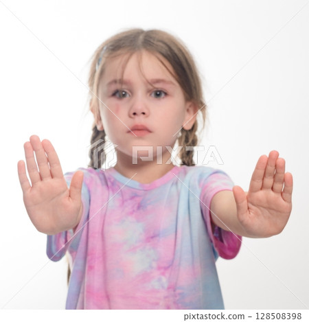 Young girl with pigtails showing stop gesture. 128508398