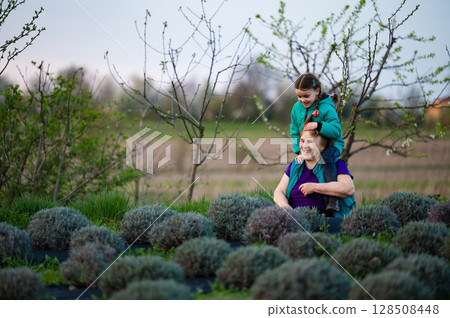 Grandmother and granddaughter enjoying a moment together in a lavender field. 128508448