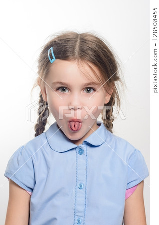 Playful young girl sticking her tongue out. A fun, candid portrait. Playful young girl sticking her tongue out. A fun, candid portrait. 128508455