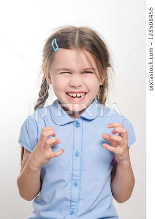 A young girl with a playful, mischievous expression, making funny faces. A young girl with a playful, mischievous expression, making funny faces. 128508456