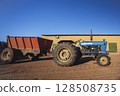 An agricultural tractor without cab in parking lot in hot country. 128508735