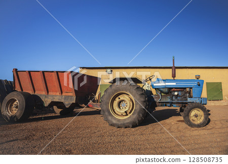 An agricultural tractor without cab in parking lot in hot country. 128508735