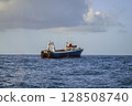 Fishing vessel is conducting an industrial catch of wild marine products using deep-sea trawl. 128508740