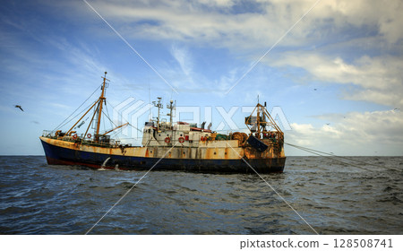 An old fishing trawler is fishing in distant oceanic waters. 128508741