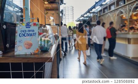 Rotterdam, Netherlands - July 12, 2025. A lively scene inside Markthal Rotterdam with diverse food stalls, neon signage, and international visitors exploring the iconic indoor market. 128508892
