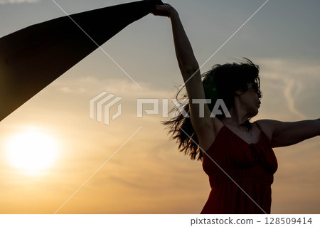 Woman and Wind at Sunset 128509414