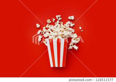 Striped box with popcorn on a red background 128511577