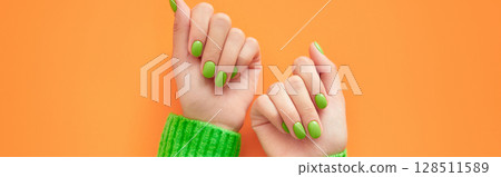 Beautiful womans hands with spring autumn nail design on orange background. Manicure, pedicure beauty salon concept. Beautiful womans hands with spring autumn nail design on orange background. Manicure, pedicure beauty salon concept. 128511589
