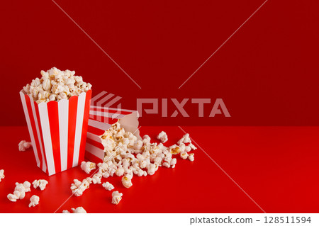 Striped boxes with popcorn on a red background 128511594