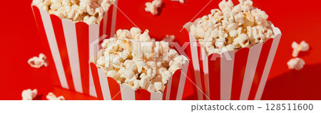 Striped boxes with popcorn on a red background 128511600