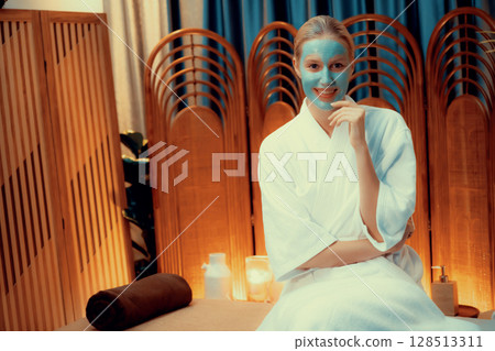 Woman indulges in rejuvenating with luxurious face cream spa massage. Quiescent Woman indulges in rejuvenating with luxurious face cream spa massage. Quiescent 128513311