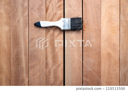 Paint brush and wood material in construction work. 128513500