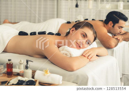 Hot stone massage at spa salon in luxury resort. Quiescent Hot stone massage at spa salon in luxury resort. Quiescent 128513554
