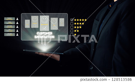 Professional hand holding a tablet displaying customer satisfaction ratings with various feedback icons and star reviews in a digital interface setting. Qubit 128513586