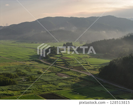 Rice fields shrouded in morning mist and shining in the morning sun, Hakuba Village, Nagano Prefecture (aerial shot by drone) 128513815