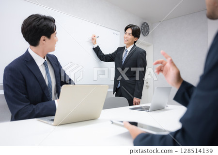 一位身著西裝的帥氣男商人在內部會議上發表演講,站在白板前發言 一位身著西裝的帥氣男商人在內部會議上發表演講,站在白板前發言 128514139