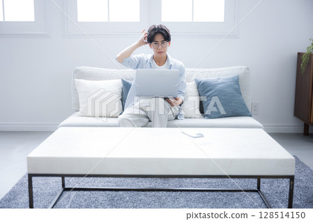 一名男子在看電腦時思考時露出的憂慮或擔憂表情的廣角鏡頭 128514150