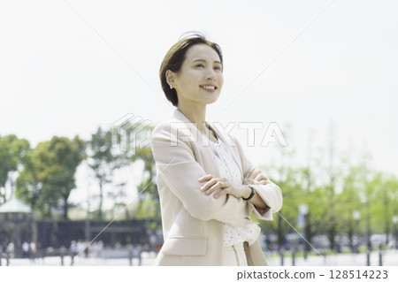 一位年輕女商人雙手交叉站在戶外的畫像 128514223