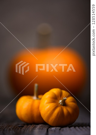 Large and small orange pumpkins on old wooden table. Large and small orange pumpkins on old wooden table. 128514559
