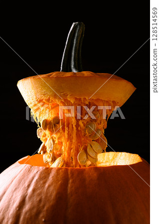 Open large orange pumpkin on black background 128514569