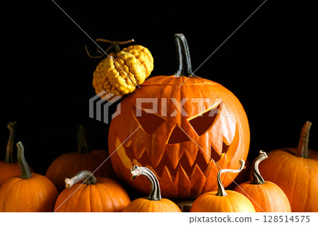 Pumpkin lantern sits among mini pumpkins Pumpkin lantern sits among mini pumpkins 128514575