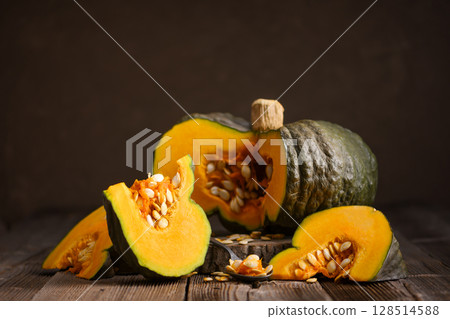 Sliced green pumpkin with bright orange flesh 128514588