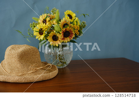 Sunflower arrangement and straw hat on a blue background 128514718