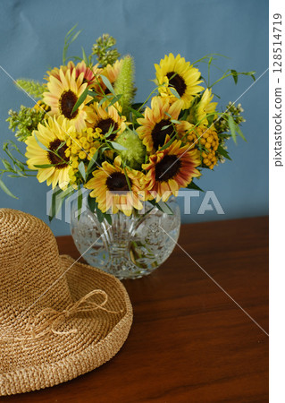 藍色背景上的向日葵佈置和草帽 128514719