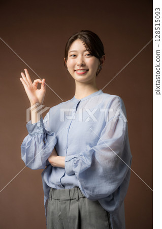 A smiling woman with a brown background, suitable for business situations, making an OK pose A smiling woman with a brown background, suitable for business situations, making an OK pose 128515093