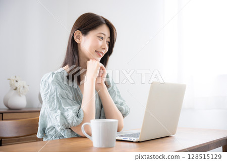 Young cute casual clothing woman using a laptop in her home room, copy space on the right 128515129