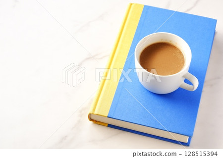 一個人一邊喝著現煮的咖啡一邊放鬆並享受一本書的圖片。 128515394