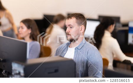 Young man working on computer in office 128516015