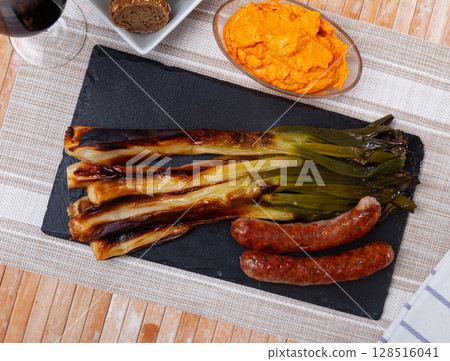 Catalan roasted calcots with romesco sauce and grilled butifarra 128516041