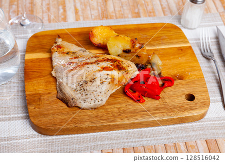 Tasty grilled pork with fried potatoes and stewed peppers served on board Tasty grilled pork with fried potatoes and stewed peppers served on board 128516042