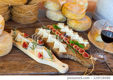 Cheese plate - cheeses and figs on wooden background Cheese plate - cheeses and figs on wooden background 128516080