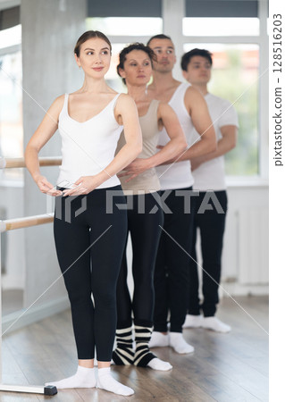Amateur ballerina mastering first position at barre in ballet studio Amateur ballerina mastering first position at barre in ballet studio 128516203