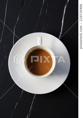 A top-down view of a coffee cup filled with freshly brewed coffee (café latte) A top-down view of a coffee cup filled with freshly brewed coffee (café latte) 128516466