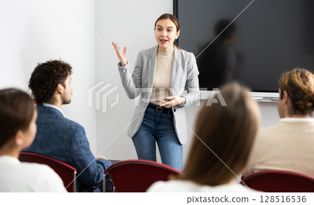 Young female teacher giving lecture to group of student 128516536