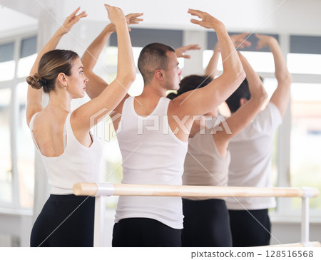 Rear view of woman practicing classic ballet postures in studio Rear view of woman practicing classic ballet postures in studio 128516568