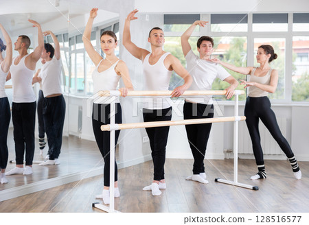Female trainer corrects dancers at barre Female trainer corrects dancers at barre 128516577