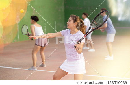 Woman playing frontenis on outdoor pelota court 128516689