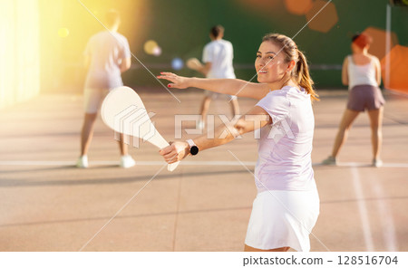 Woman Basque pelota player hitting ball with wooden racket 128516704