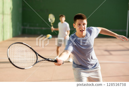 Emotional guy playing frontenis on open court on summer day Emotional guy playing frontenis on open court on summer day 128516738